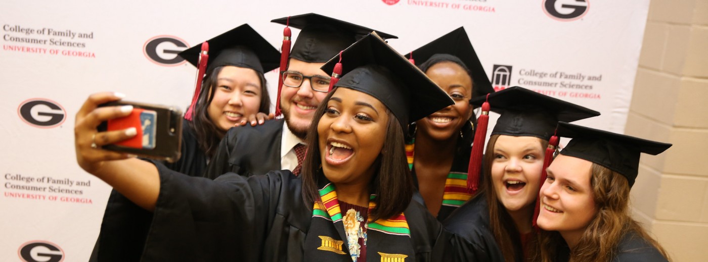 graduates in gowns taking selfie